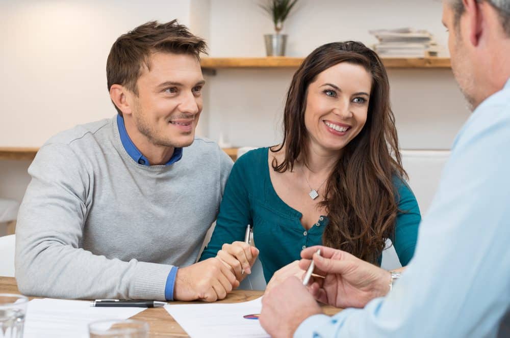 young couple discussing investment with mortgage broker